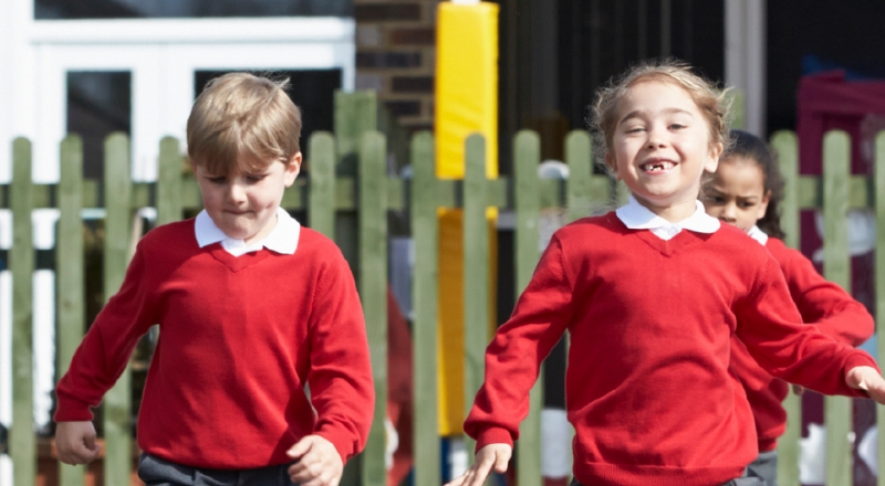 Two schoolchildren play in school playground